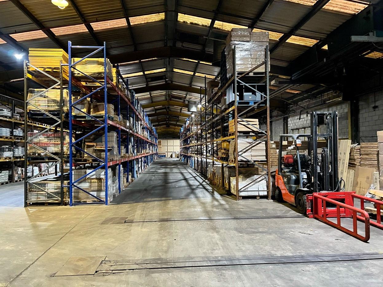 Toyota forklift operating between loaded pallet racking aisles at Laporsa warehouse