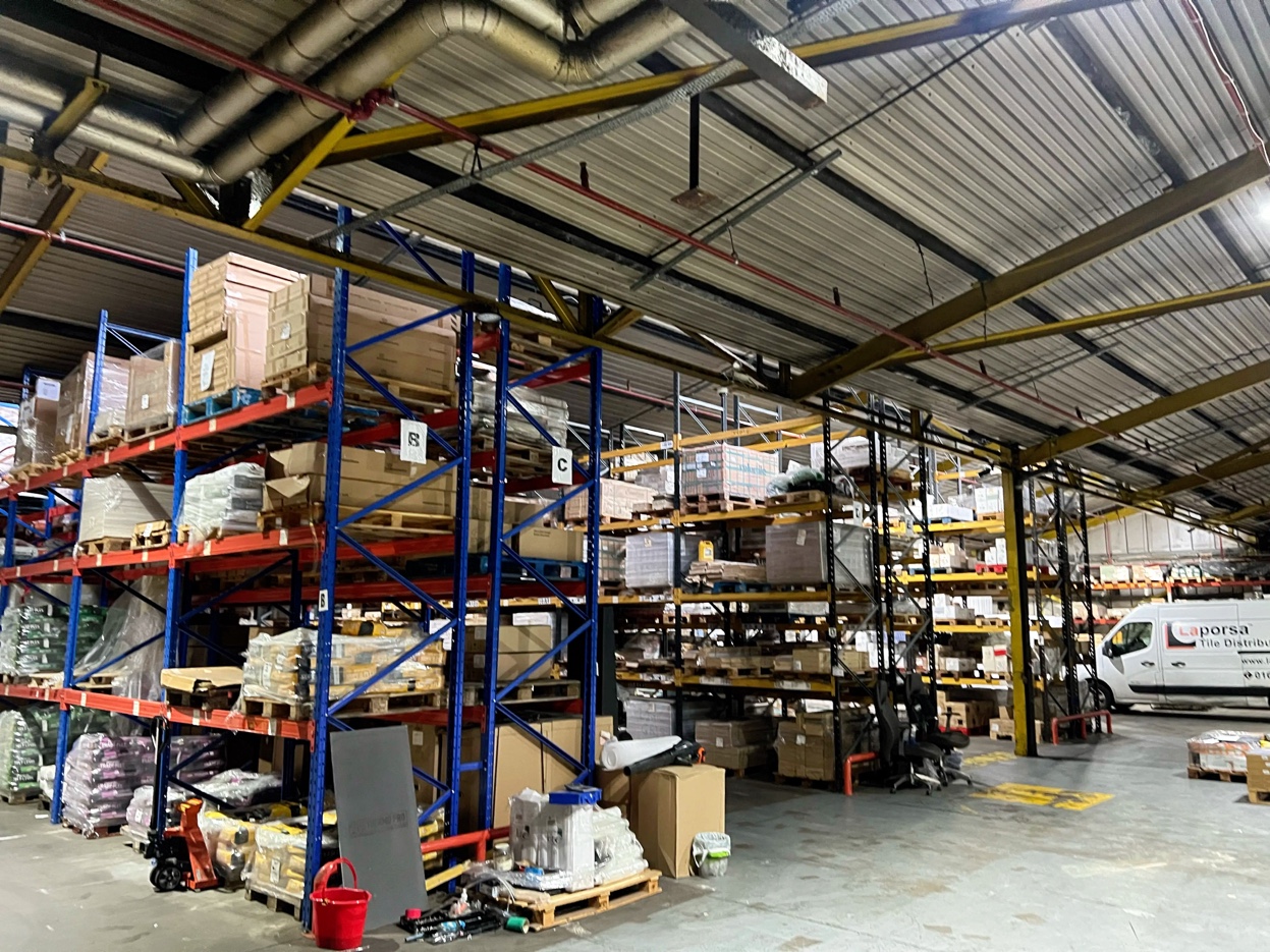 Wide interior of Laporsa warehouse showing industrial racking system and delivery operations